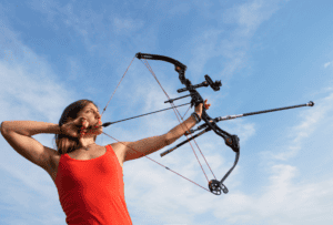 Woman in a red top at archery shooting pratice 