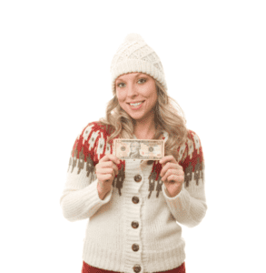 Woman in a wooly hat and Christmas jumper holding aloft a dollar bill